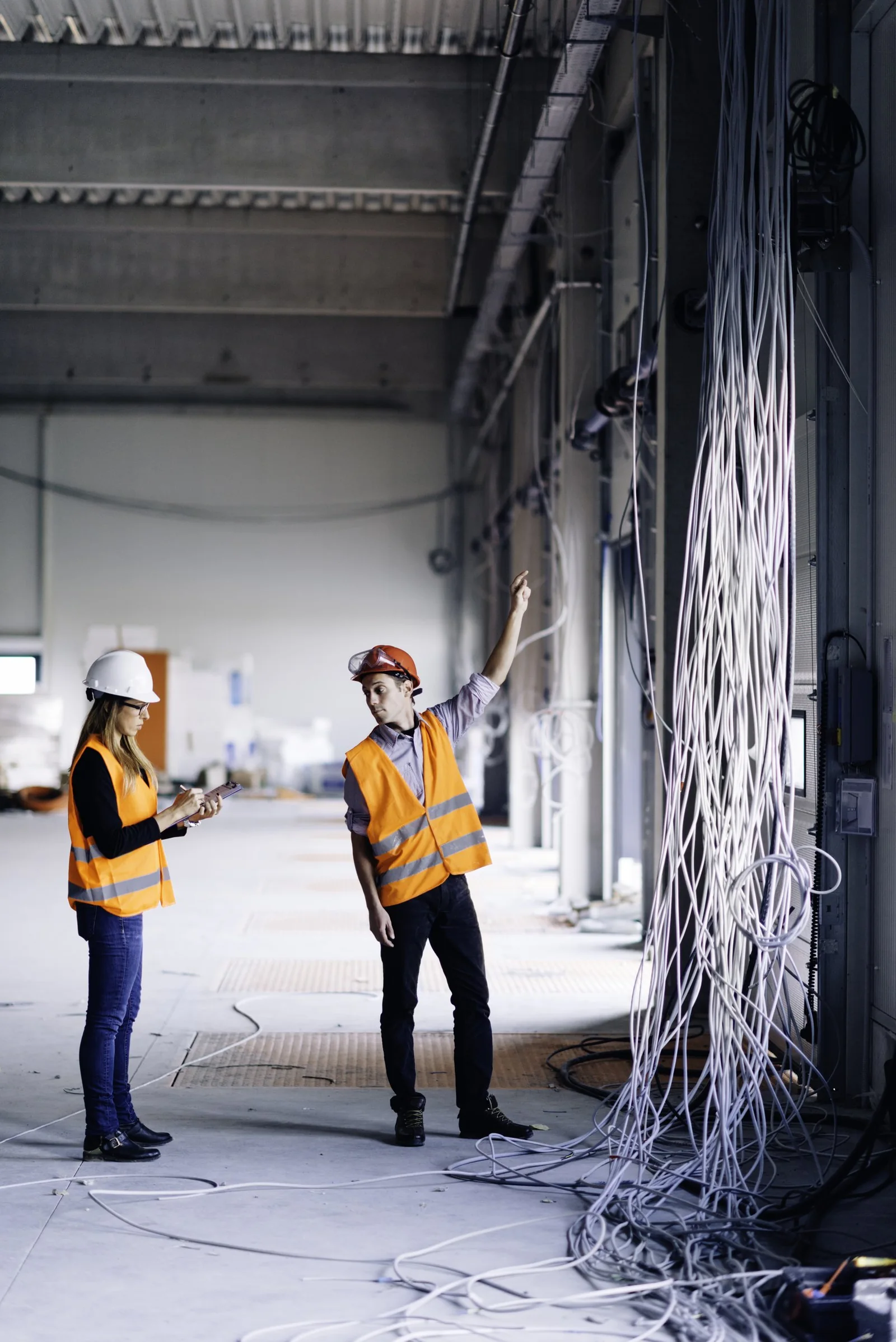 Engenheira e técnico num edifício industrial